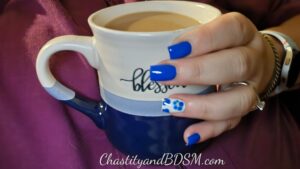 Her hand, with painted nails, wrapped around a mug full of delicious looking coffee. 